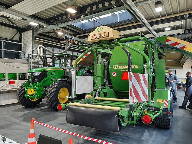 Prüfungssituation im Bereich «Facharbeiten ausführen Landmaschinen» mit Maschinen der Marken John Deere, Krone und Fendt.